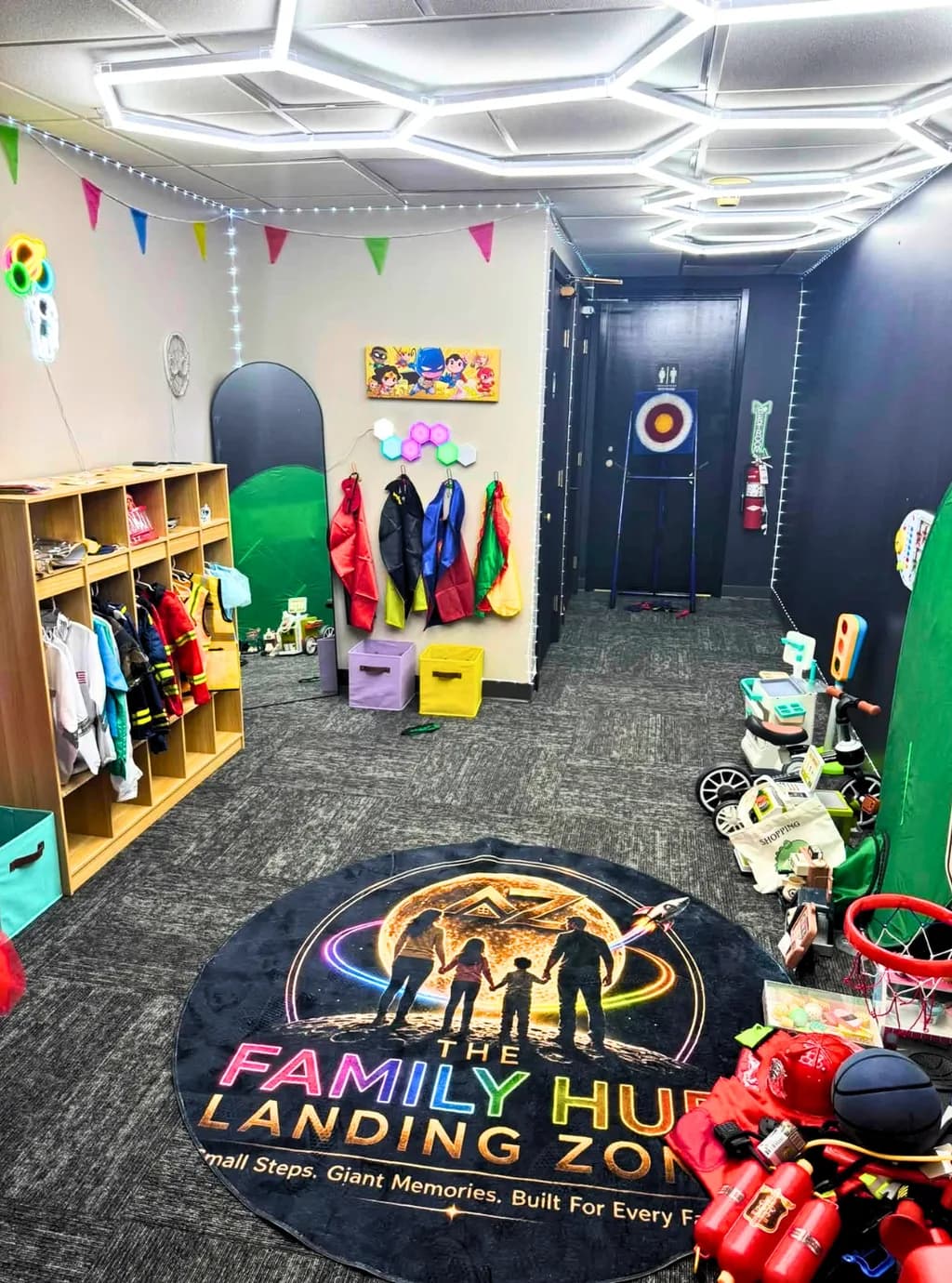 Dress up area with capes on hooks, costume lockers, and a Family Hub Landing Zone floor rug.