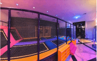 Foam block pit filled with pink, green, and purple cubes beside the trampoline beds.